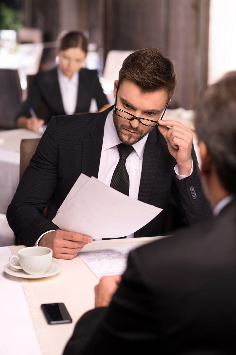 Business people at the restaurant. Business people in formalwear discussing something while sitting at the restaurant